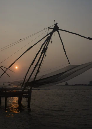 Chinese fishing nets silhouetted at sunset in Fort Kochi